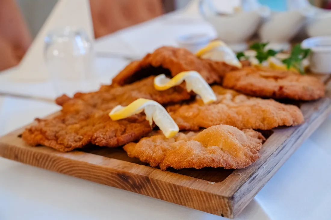 Goldbraune Schnitzel mit Zitrone auf einem Holzbrett