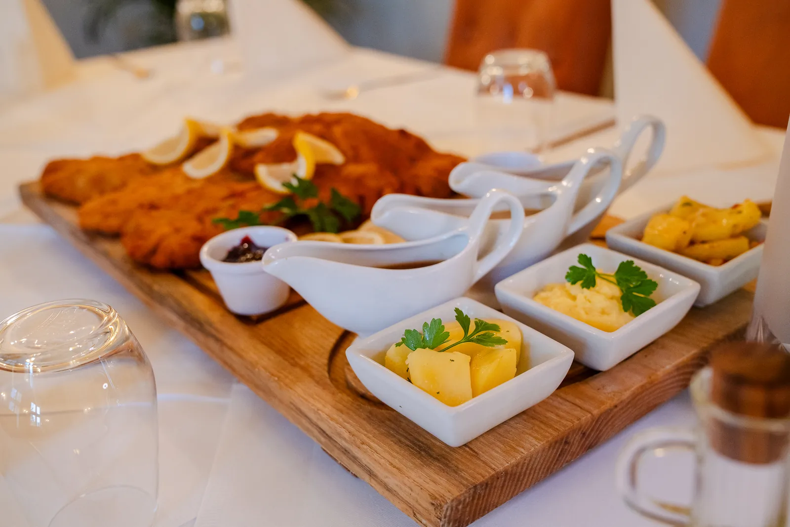 Beilagen und Saucen in kleinen Schälchen neben Schnitzeln