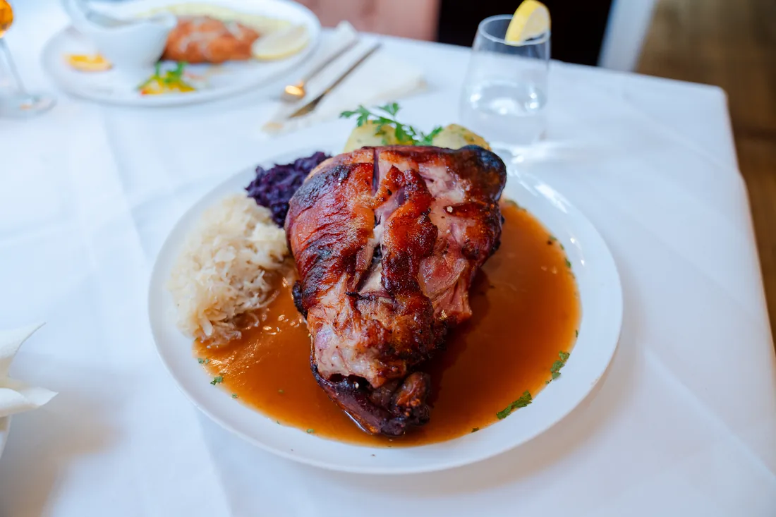 Schweinshaxe mit Sauce, Sauerkraut und Rotkohl