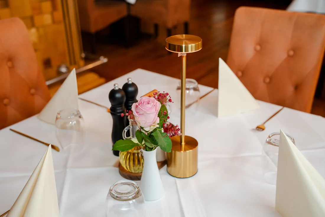 Gedeckter Tisch mit Blumen und Tischlampe